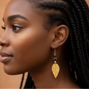 Woman with braided hair wearing gold earrings against a warm brown background