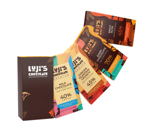 An array of Luji's Chocolate bars laid out diagonally, showcasing vibrant wrappers with African-inspired patterns for flavors including Dark Chocolate, Milk Chocolate, Ginger Plantain Crunch, and Spicy Suya