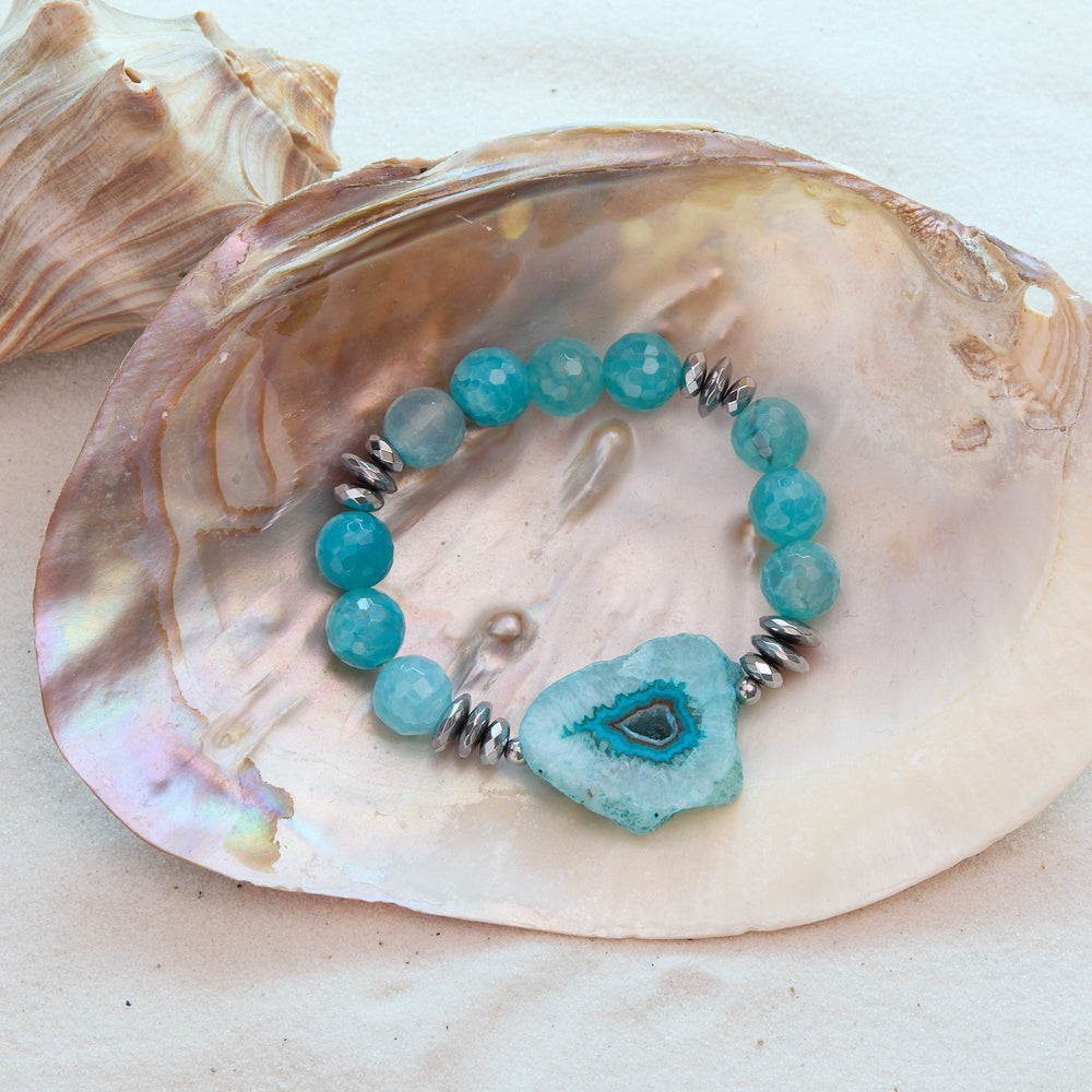 Turquoise beaded bracelet with a large blue stone on a seashell