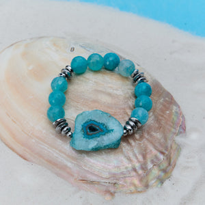 Turquoise beaded bracelet with a central crystal on a seashell