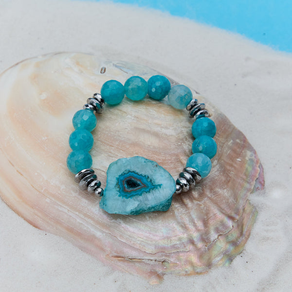 Turquoise beaded bracelet with a central crystal on a seashell