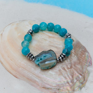 Turquoise beaded bracelet with a large central stone on a seashell