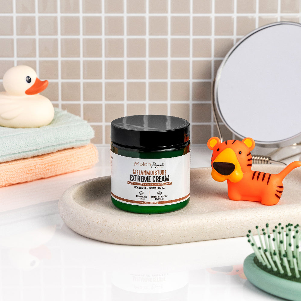 Jar of MelanoMoisture Extreme Cream on a bathroom counter with a mirror and toys in the background.