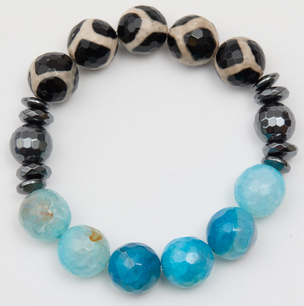 Bracelet with black and white patterned beads, blue beads, and gray beads on a white background