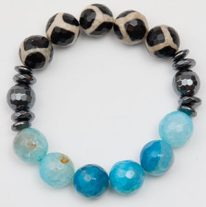 Bracelet with black and white patterned beads and blue faceted beads on a white background