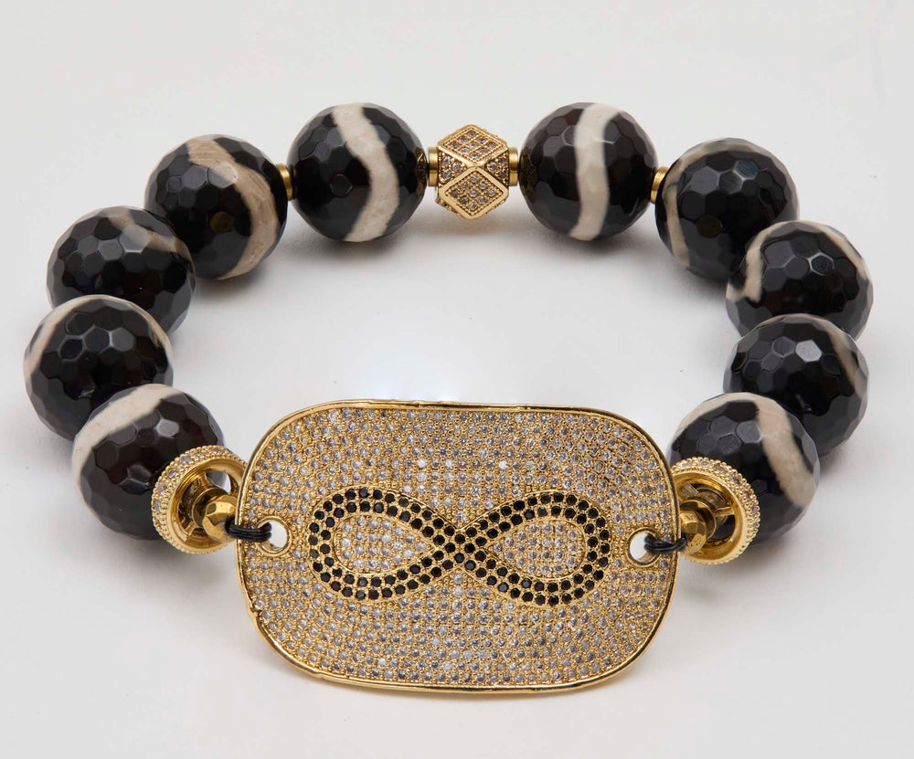 Bracelet with black beads and gold-plated infinity focal  on a white background