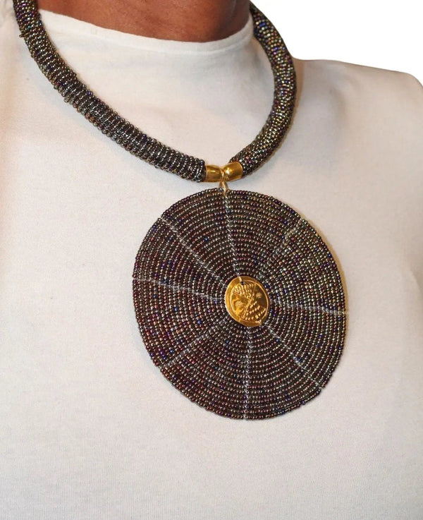 A model wearing a circular black beaded necklace with gold accents.