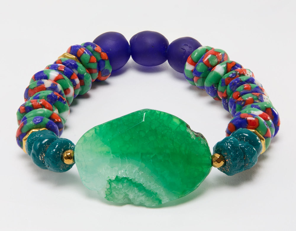 Colorful beaded bracelet with a large green stone on a white background