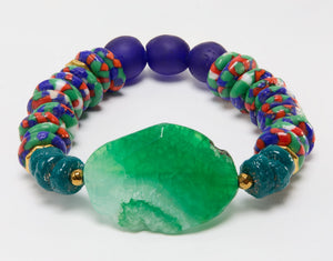 Colorful beaded bracelet with a large green stone on a white background