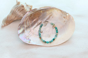 Beaded bracelet on a large shell with a white background