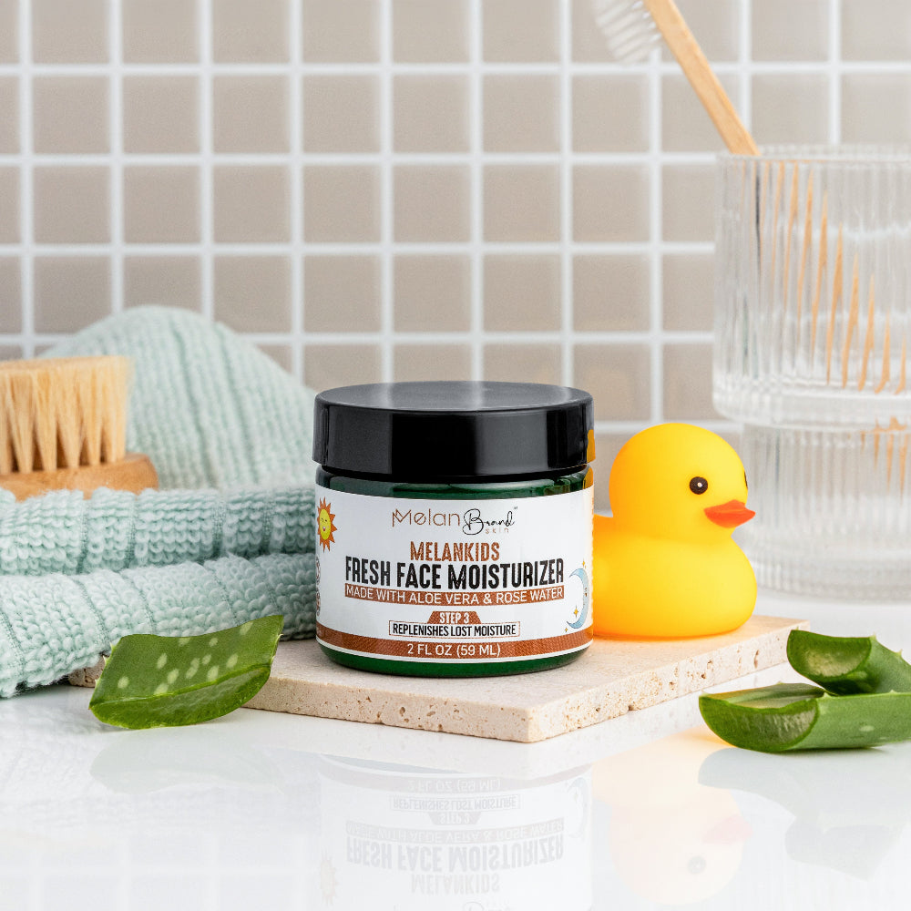 Jar of fresh face moisturizer with a rubber duck and aloe vera leaves on a bathroom counter.