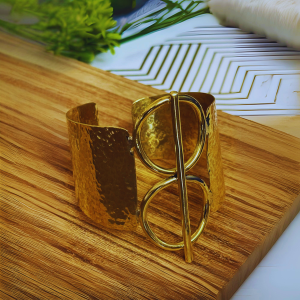 Gold bracelet on a wooden surface with a blurred background