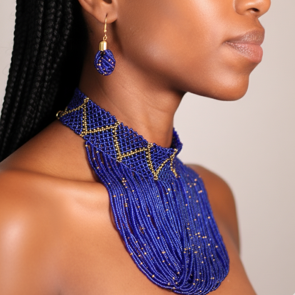 A woman wearing a blue beaded necklace and earrings on a neutral background
