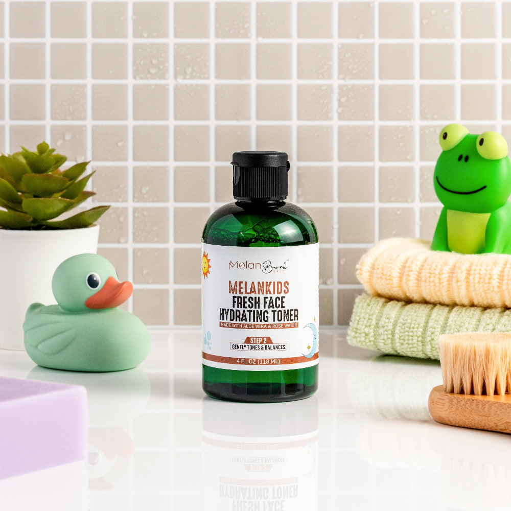Melankids Fresh Face Hydrating Toner bottle on a bathroom counter with toys and a plant in the background.