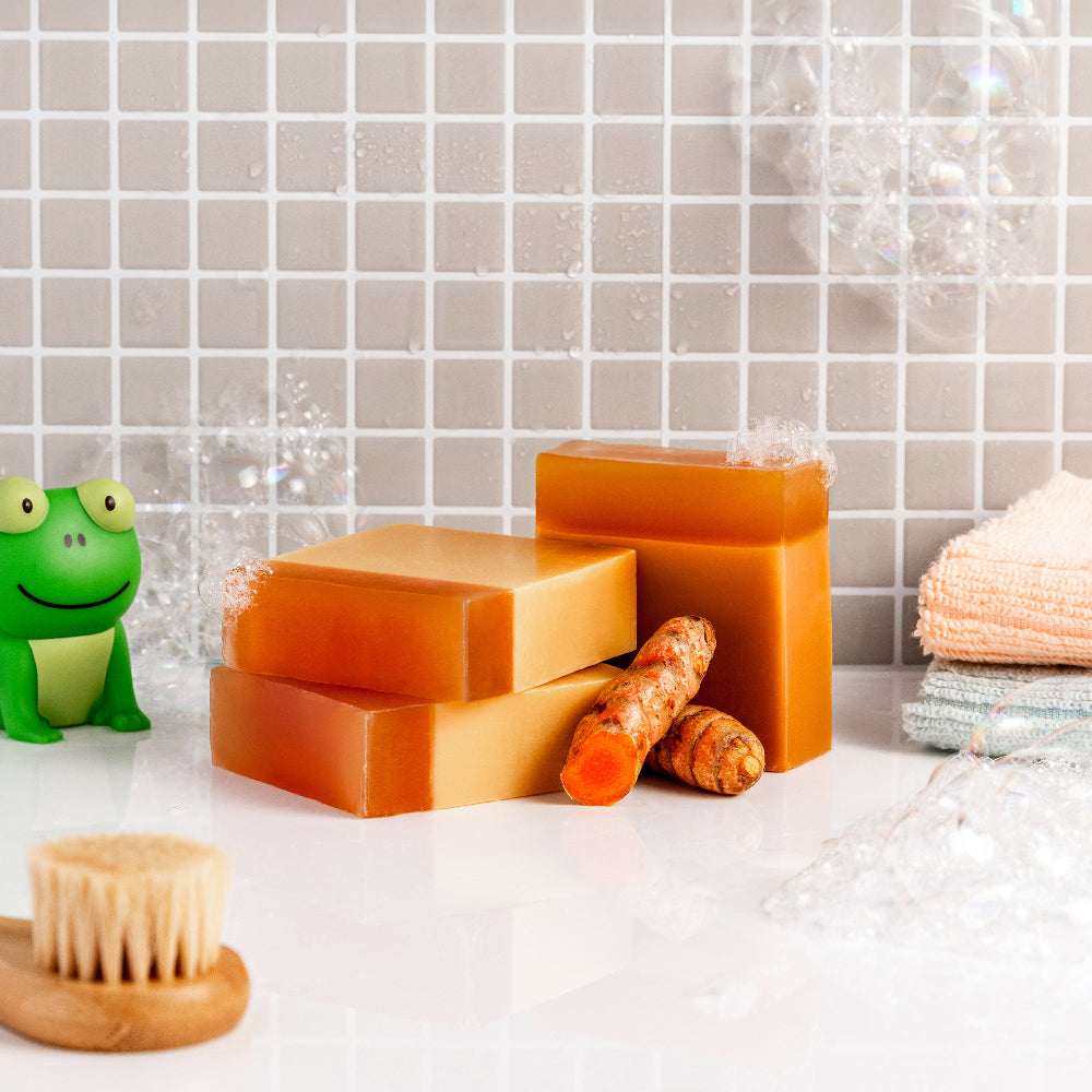 Three bars of Turmeric Acne soap Bars on a white surface with a tiled wall background