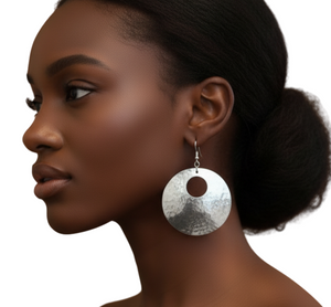 Silver earrings worn by a model on a white background