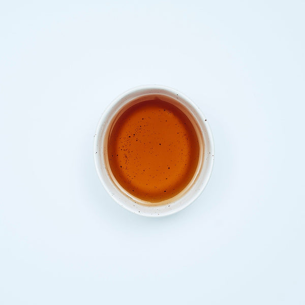 "Smooth September herbal tea blend with cayenne pepper, bay leaf, and mullein in biodegradable tea sachet bags inside a 16oz resealable pouch, displayed beside a steaming tea mug."