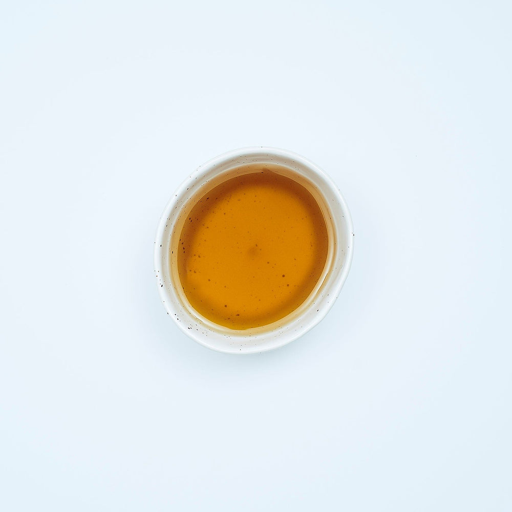 Smooth September, A natural herbal arrangement featuring dandelion leaf, fresh ginger root, nettle leaves, chamomile flowers, and dried burdock root on a yellow golden background.