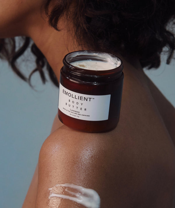 Jar of handmade lavender body butter for dry and eczema - prone skin on a woman's shoulder