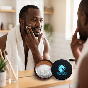 Black man applying Certified Organic Face Moisturizer at a bathroom mirror after a shower