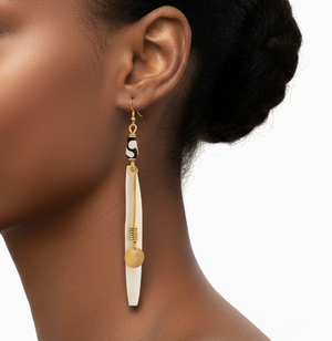 Woman wearing a gold and white earring on a white background