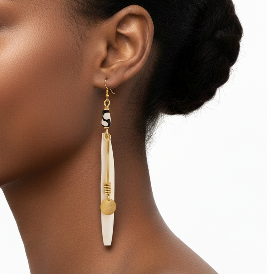 Woman wearing a gold and white earring on a white background