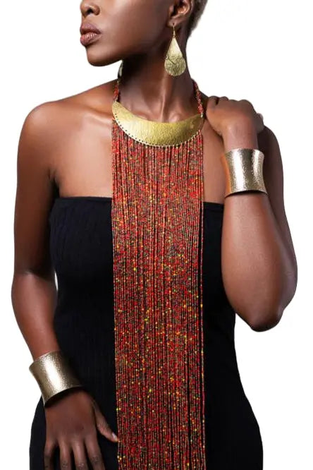 Woman wearing gold jewelry including a necklace, earrings, and bracelets on a white background