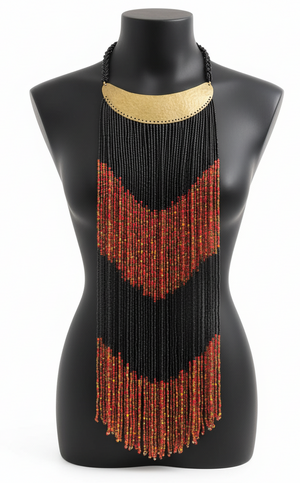 Beaded necklace with black and gold top and red fringe on a mannequin.