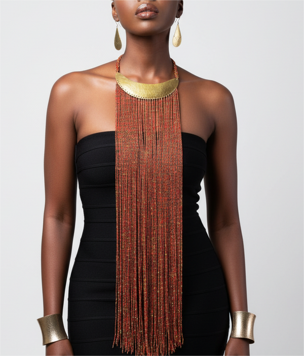 A woman wearing a long, beaded necklace with a brass plate on a plain background