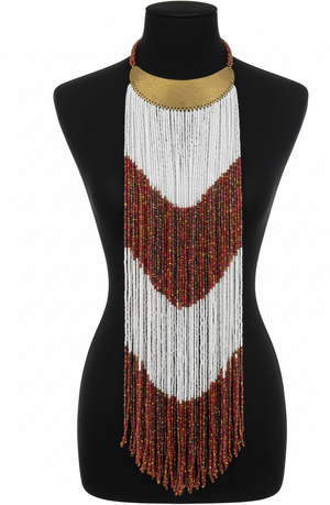 A long beaded necklace with white and red pattern on a black mannequin