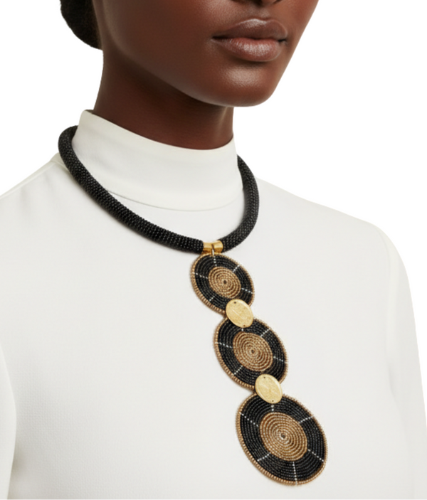 Woman wearing a long, ornate necklace with 3 discs and a copper shilling connecting them on a white background