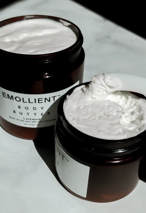 Two jars of My Emollient body butter on marble surface with minimal packaging and clean skincare aesthetic
