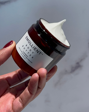 Hand holding My Emollient lavender body butter jar with smooth whipped peak texture, non-toxic clean skincare moisturizer