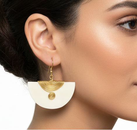 Woman wearing gold earrings with a white background